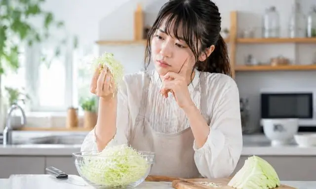 千切りキャベツが苦くなる原因と見分け方を確認する女性