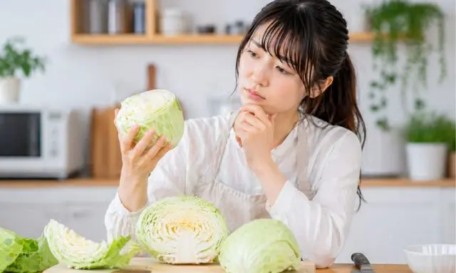 キャベツが腐っているか判断するチェックポイントを確認する女性