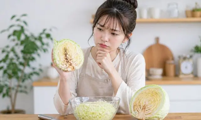 キャベツの切り口が茶色く変色した断面を見て食べて大丈夫か迷う女性